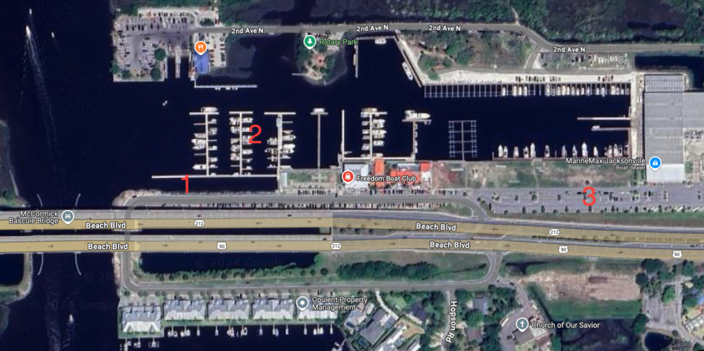 A satellite view of a marina complex along Beach Boulevard in Jacksonville, Florida. Several docks stretch into the water, with boats lined up in the marina slips. Key areas are numbered, with "1" marking a dock, "2" marking an area with boats in the water, and "3" marking a parking area. Freedom Boat Club is located in the central part of the image, near the docks, and MarineMax Jacksonville is visible to the right. The McCormick Bascule Bridge crosses the water on the left side. Various streets, including 2nd Ave N, are labeled in the surrounding areas.